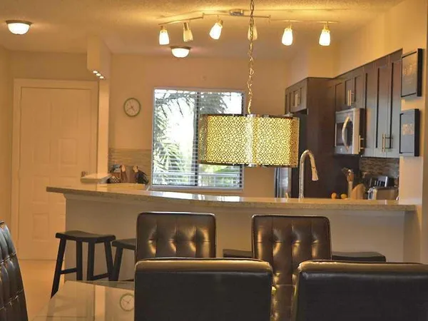 a kitchen with stainless steel appliances granite countertop a sink and a refrigerator