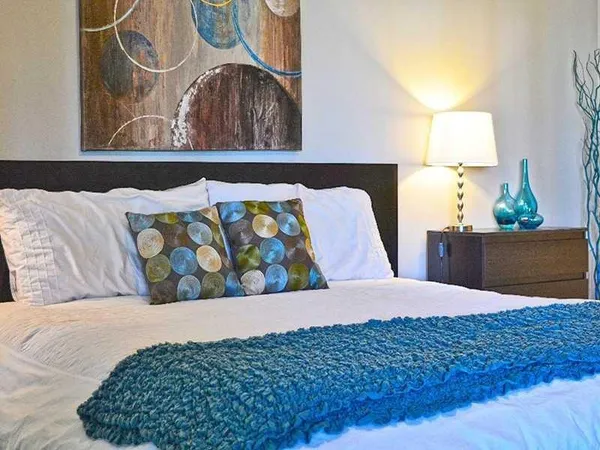 a bedroom with a bed and painting on the wall