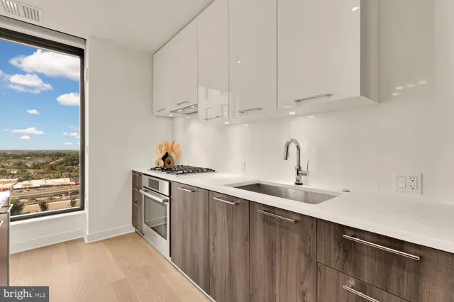 a kitchen with stainless steel appliances a sink stove and cabinets