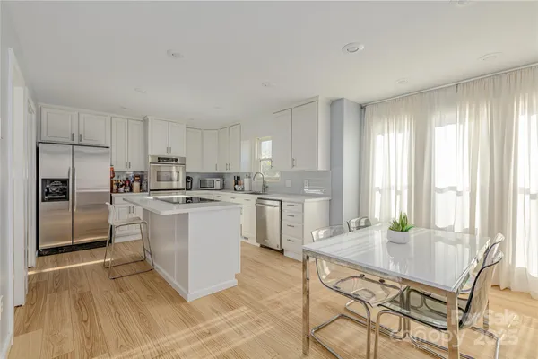 a kitchen with stainless steel appliances granite countertop a stove a sink and a refrigerator