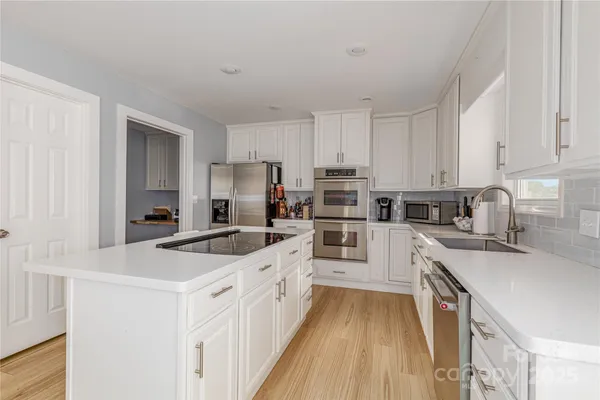 a view of a kitchen with stainless steel appliances granite countertop a stove and a refrigerator