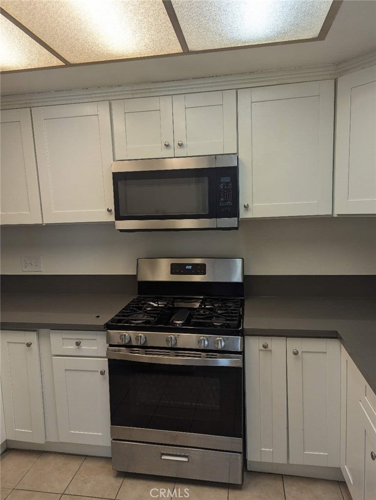 64 Tangerine Irvine, CA 92618 - Photo 13 of 32 a kitchen with white cabinets and black appliances