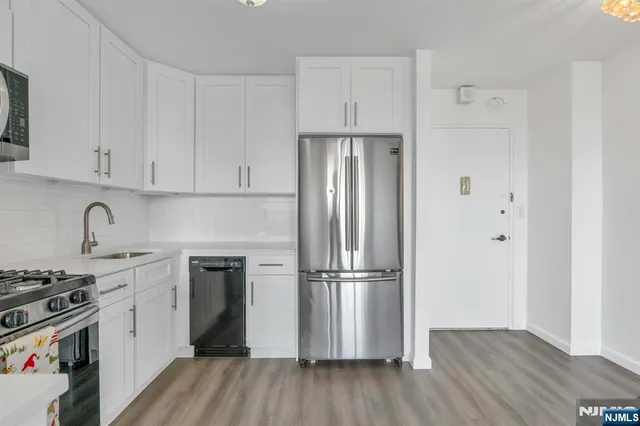 a kitchen with a refrigerator stove and wooden cabinets