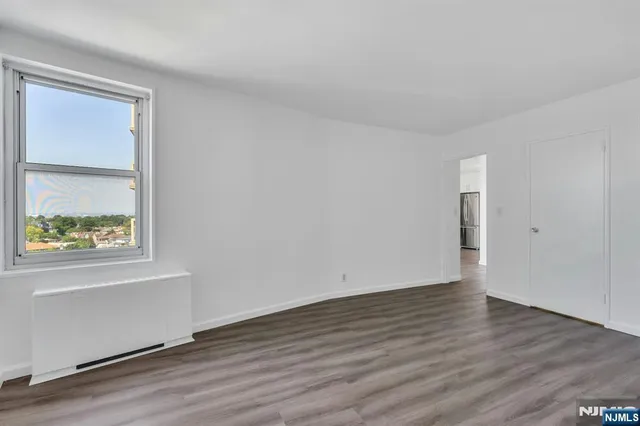 an empty room with wooden floor and a window