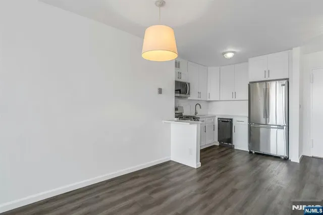 a kitchen with a refrigerator a microwave and wooden floor