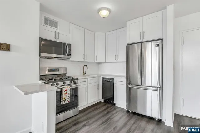 a kitchen with stainless steel appliances a refrigerator stove and microwave