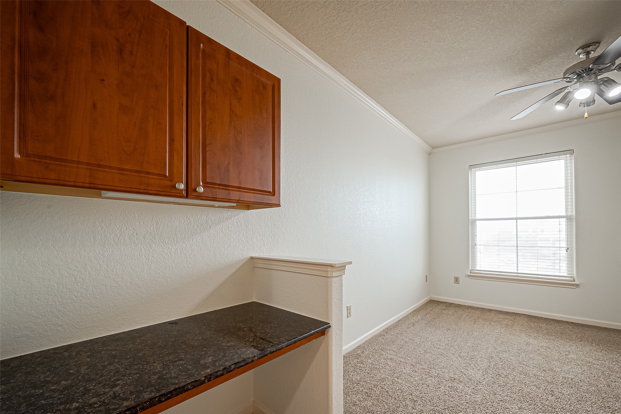 1711 Old Spanish Trail, Unit 303 Houston, TX 77054 - Photo 21 of 37 a kitchen with granite countertop white cabinets and black appliances