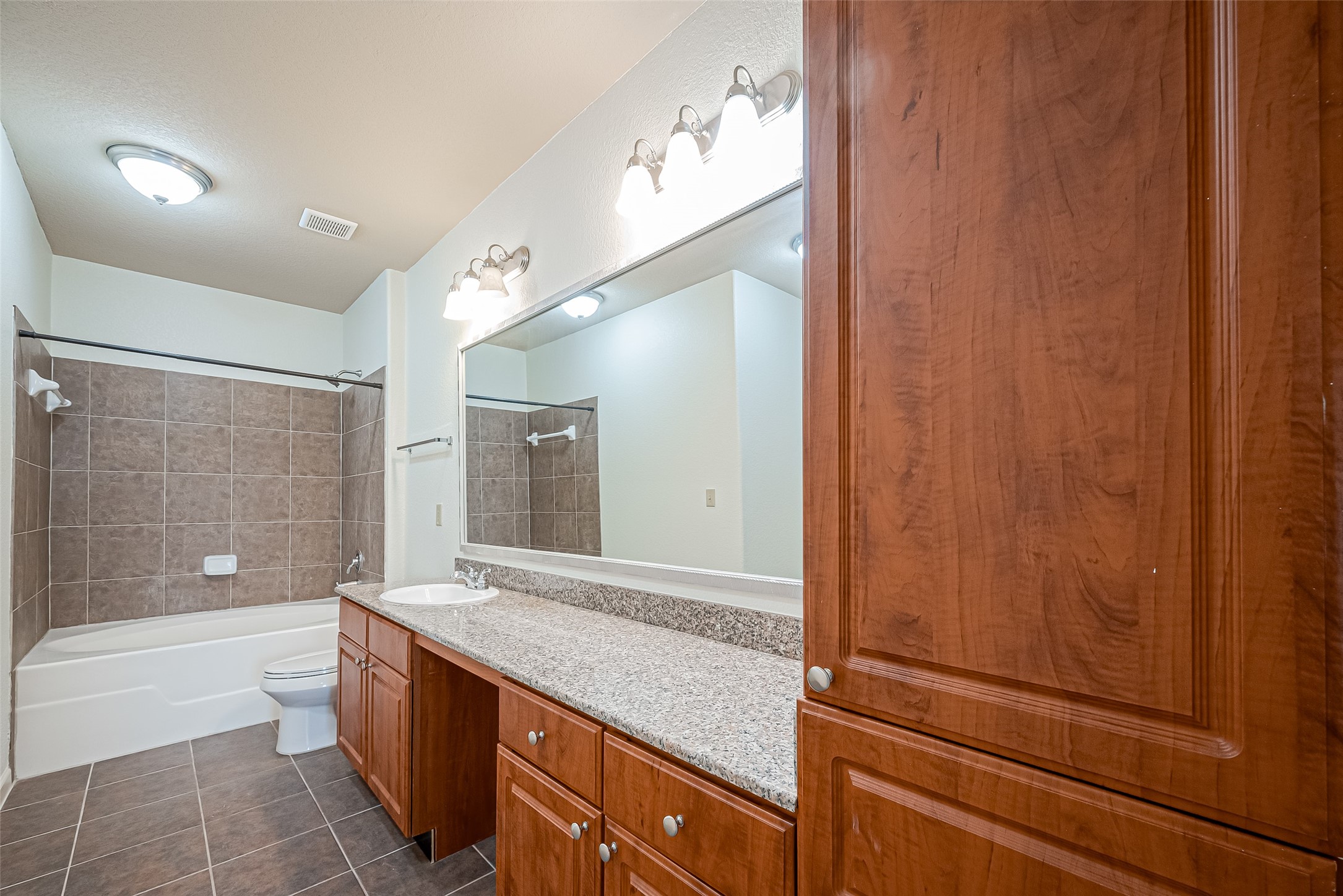 1711 Old Spanish Trail, Unit 303 Houston, TX 77054 - Photo 22 of 37 a bathroom with a granite countertop sink a toilet and shower