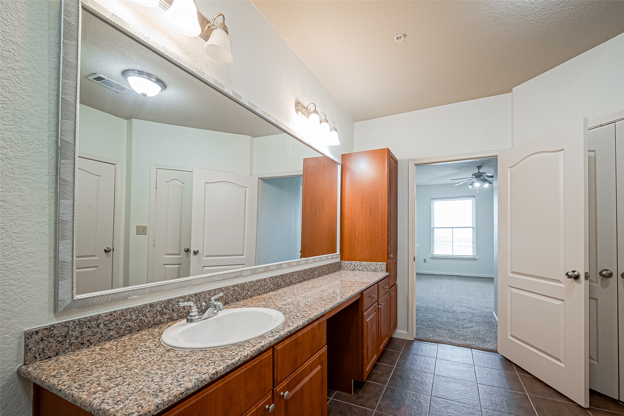 1711 Old Spanish Trail, Unit 303 Houston, TX 77054 - Photo 23 of 37 a bathroom with a granite countertop sink and a mirror