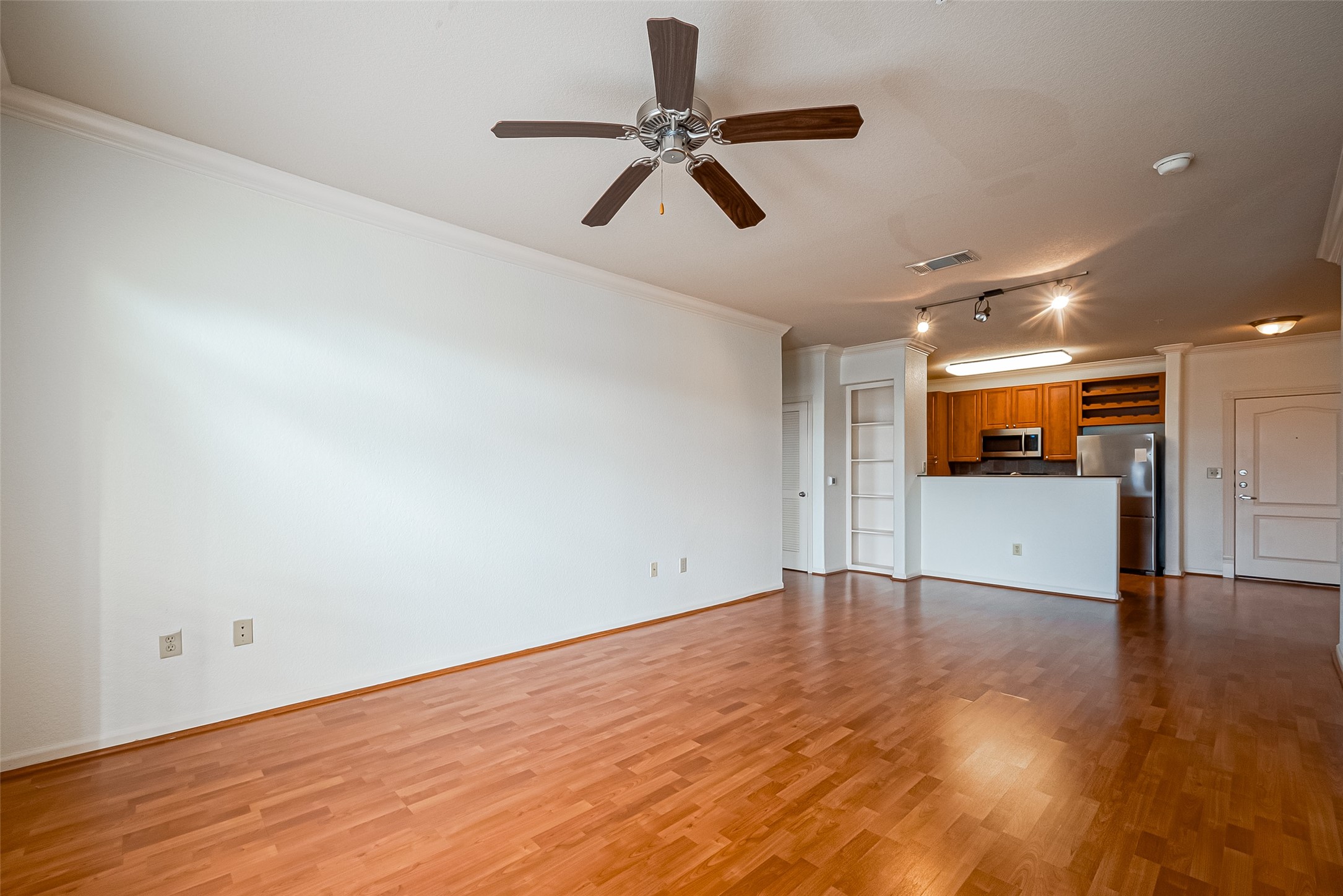 1711 Old Spanish Trail, Unit 303 Houston, TX 77054 - Photo 7 of 37 a view of an empty room with wooden floor and a ceiling fan