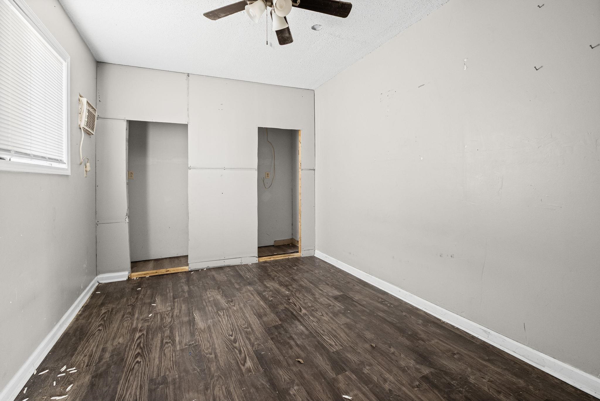 4202 Reed Avenue Memphis, TN 38108 - Photo 17 of 22 Unfurnished bedroom with dark wood-style flooring, a ceiling fan, and a textured ceiling