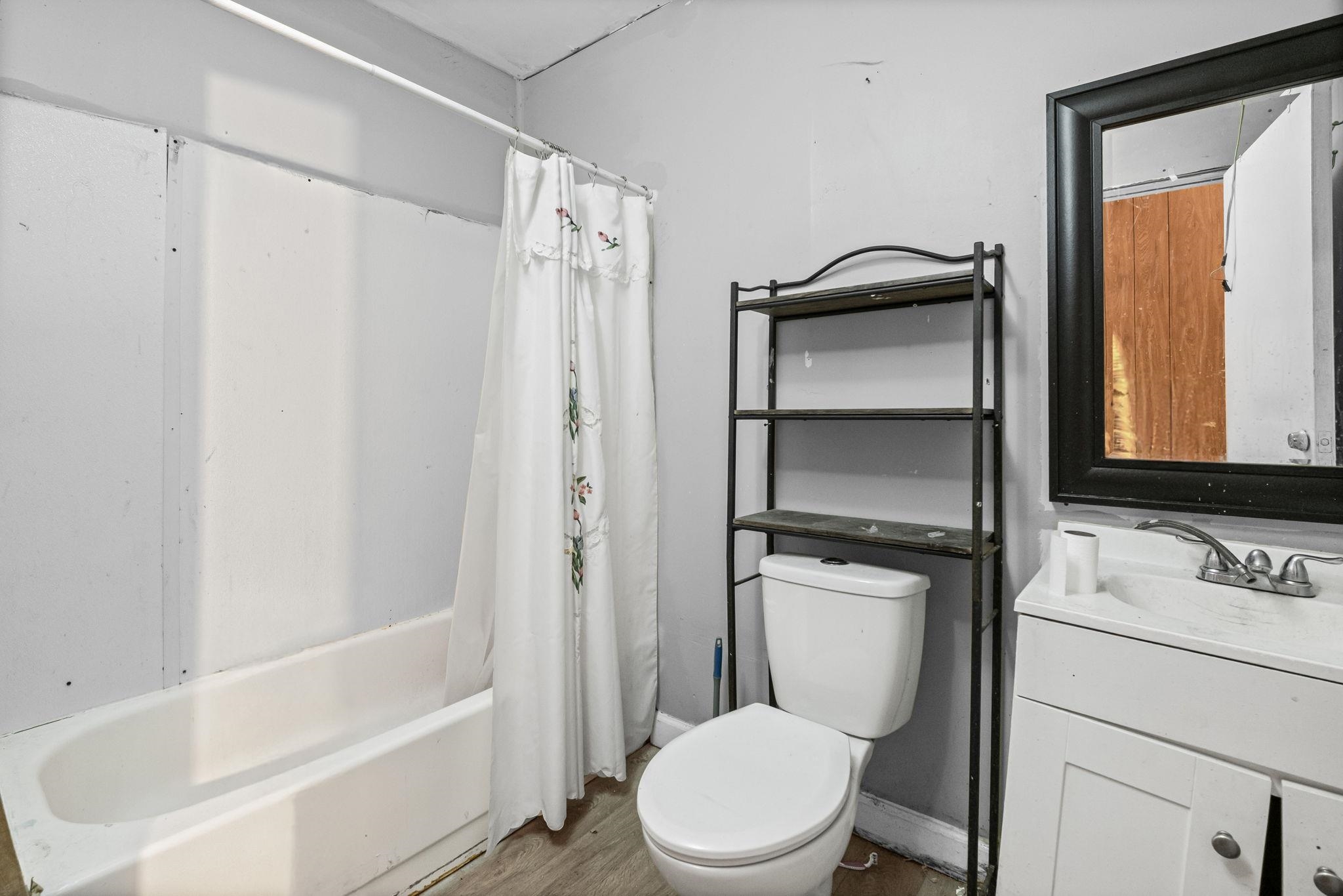4202 Reed Avenue Memphis, TN 38108 - Photo 19 of 22 Bathroom with shower / bath combination with curtain, vanity, and wood finished floors