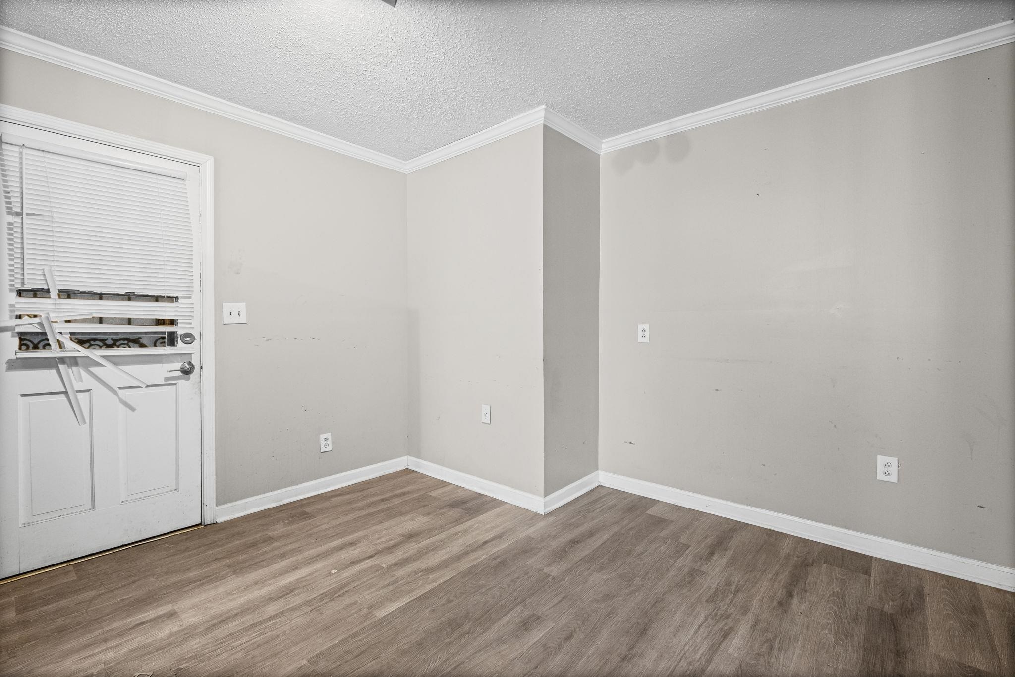 4202 Reed Avenue Memphis, TN 38108 - Photo 7 of 22 Unfurnished room with a textured ceiling, wood finished floors, and ornamental molding