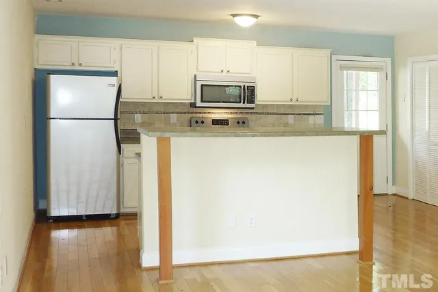 a kitchen with appliances a microwave and cabinets