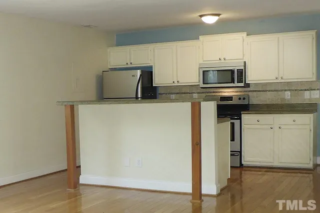a kitchen with stainless steel appliances a refrigerator a stove a microwave and cabinets