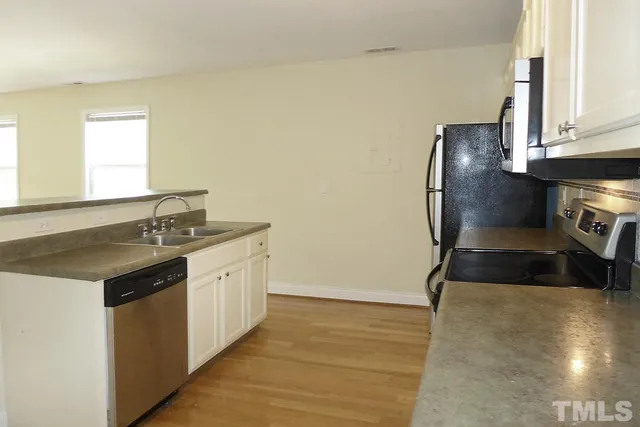 a kitchen with stainless steel appliances a sink stove and cabinets