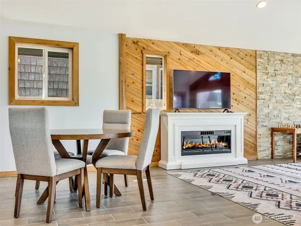 a living room with furniture a fireplace and a floor to ceiling window