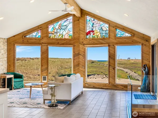 a living room with furniture a large window and a flat screen tv