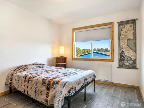 a view of a bedroom with wooden floor and windows