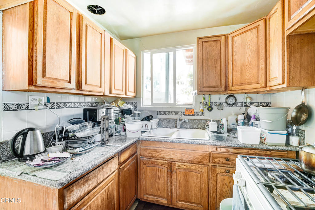 4824 Toland Way Los Angeles, CA 90041 - Photo 15 of 26 a kitchen with stainless steel appliances granite countertop a sink a stove cabinets counter space and a window