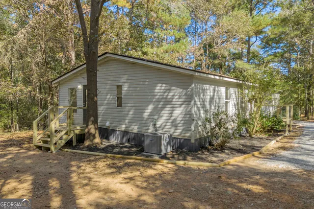 a backyard of a house with large trees and outdoor seating