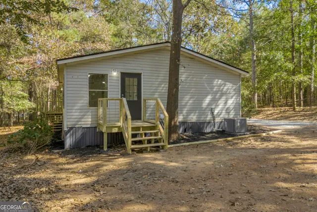 a view of a house with backyard and chairs