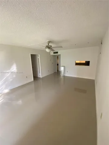 a view of a livingroom with a ceiling fan and wooden floor