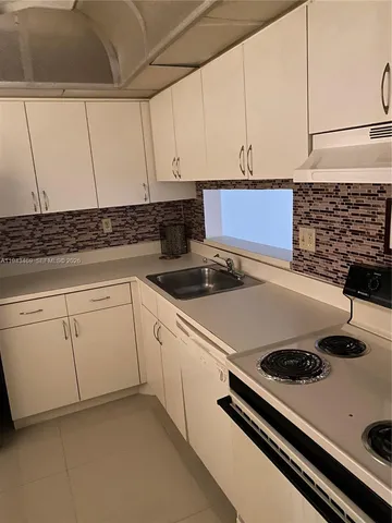 a view of a dining room with furniture a kitchen and a window