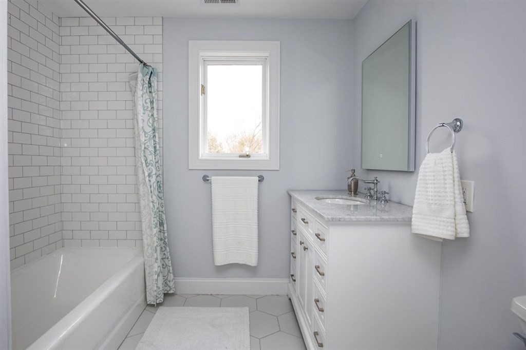 6 Rolleston Road Marblehead, MA 01945 - Photo 19 of 26 a bathroom with a granite countertop sink a mirror and a bathtub