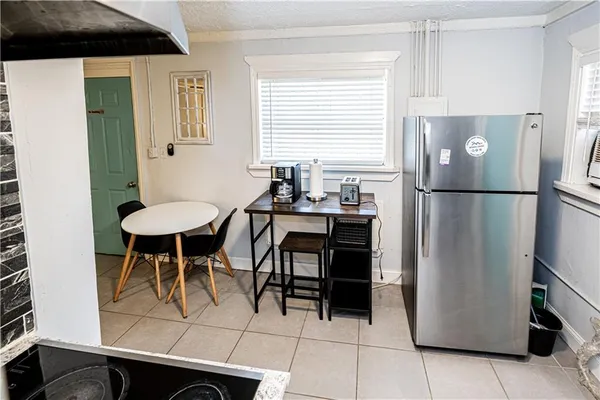 a kitchen with stainless steel appliances a refrigerator a table and chairs