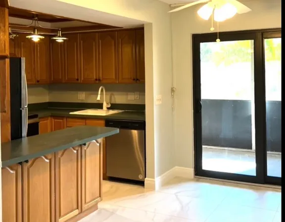a kitchen with kitchen island a counter top space cabinets stainless steel appliances and a window