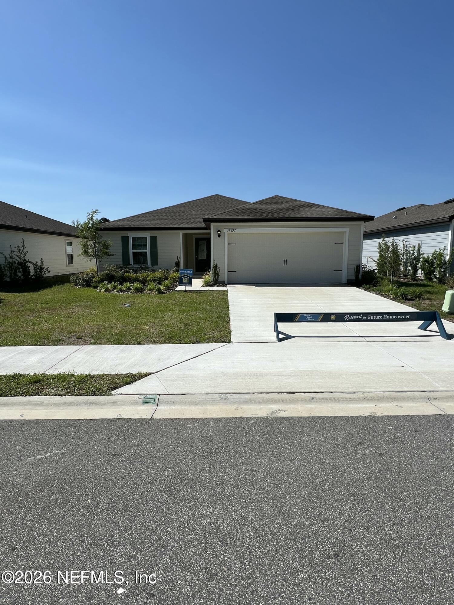 37397 Whisper Way Hilliard, FL 32046 - Photo 2 of 9 a front view of a house with a yard and garage