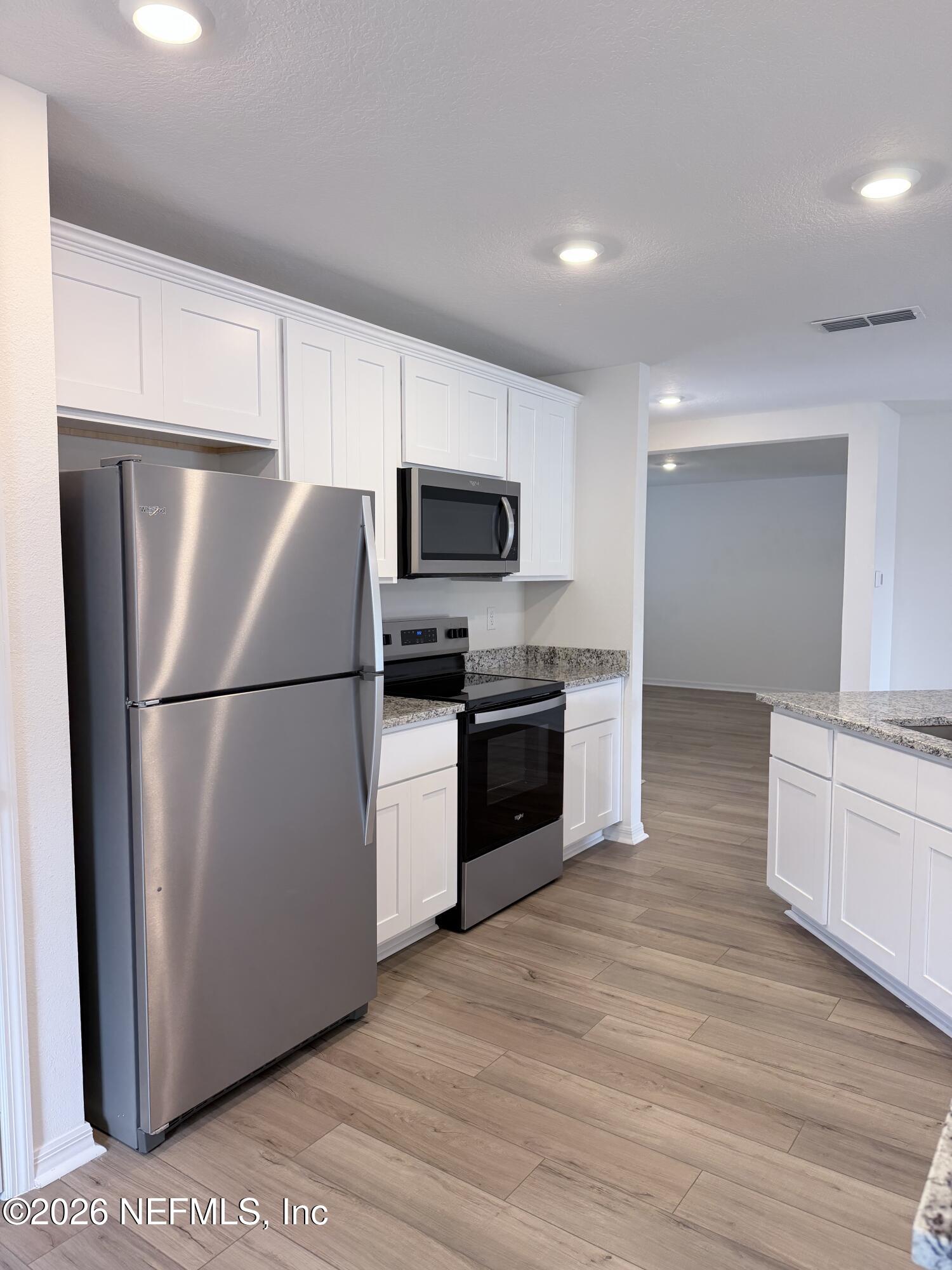 37397 Whisper Way Hilliard, FL 32046 - Photo 5 of 9 a kitchen with a refrigerator cabinets and wooden floor