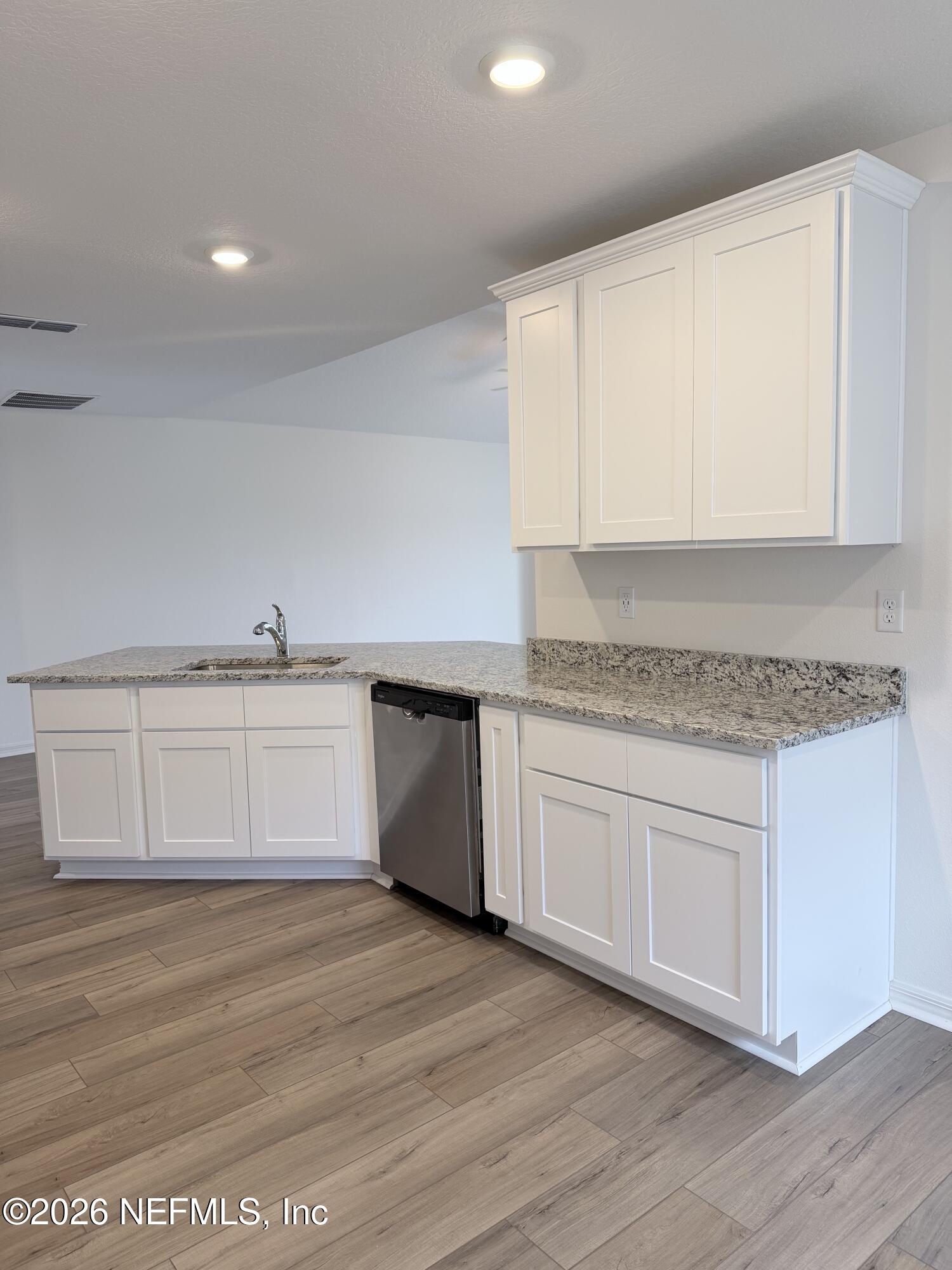 37397 Whisper Way Hilliard, FL 32046 - Photo 6 of 9 a kitchen with granite countertop white cabinets and white appliances