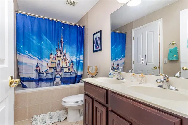 a bathroom with a sink a toilet and shower curtain