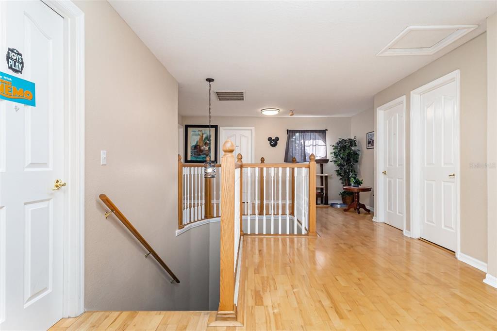 302 Vista Loop Davenport, FL 33897 - Photo 20 of 22 a view of a hallway with wooden floor stairs and a living room