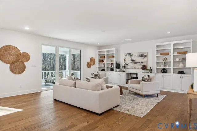 a kitchen with stainless steel appliances granite countertop a stove top oven a refrigerator a sink and a dining table with wooden floor