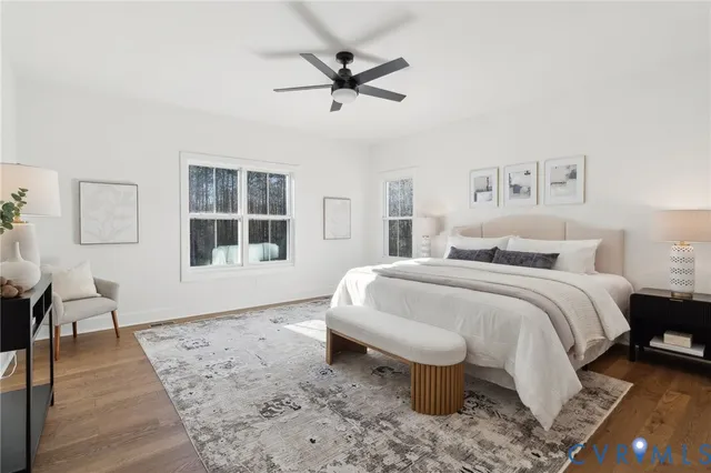 a bedroom with a bed a chair and potted plant on the table