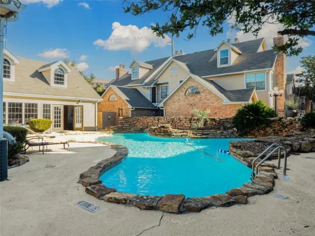 an aerial view of a house with swimming pool and patio