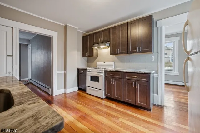 a kitchen with stainless steel appliances granite countertop a stove a refrigerator and a sink with granite countertops