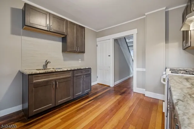 a kitchen with a sink and wooden floor