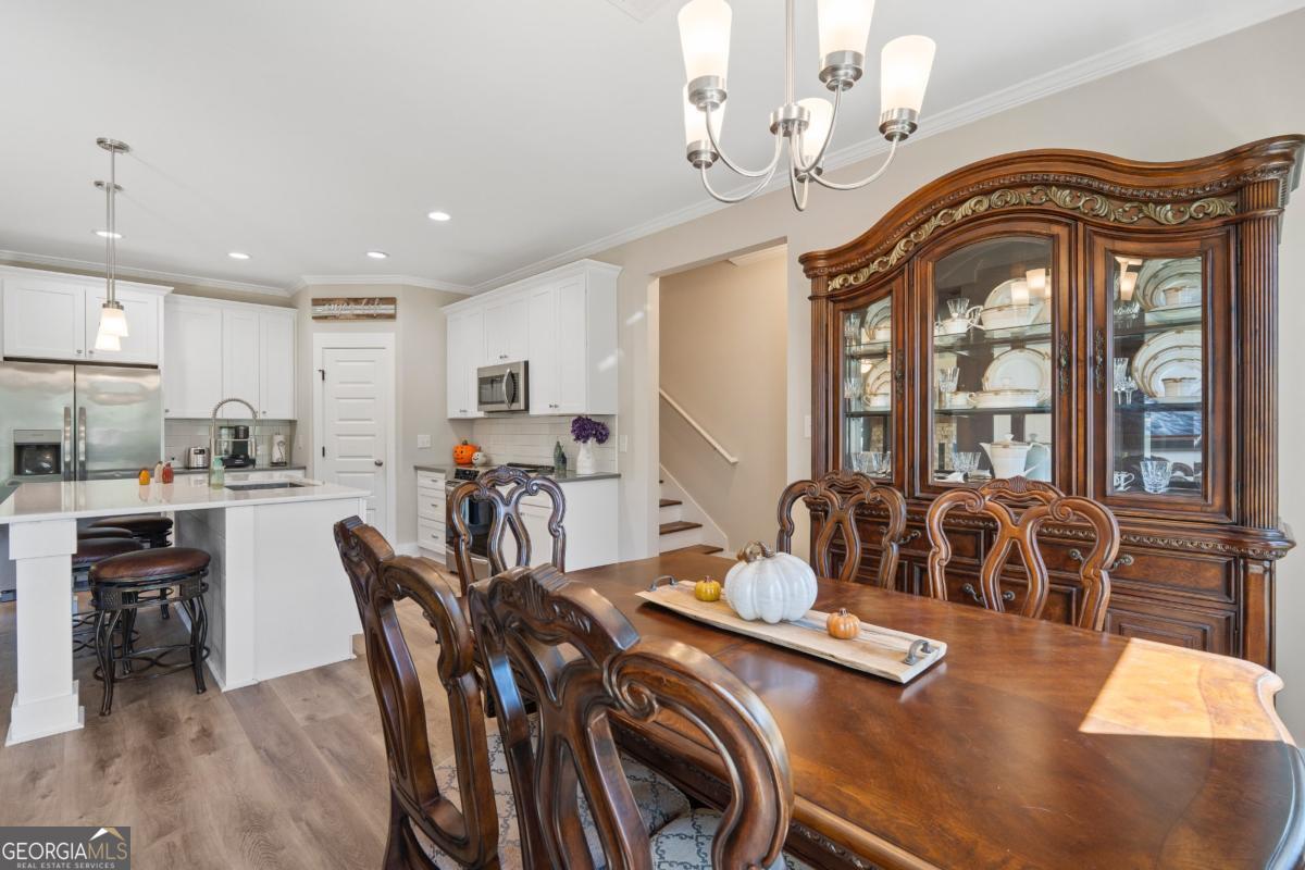 801 Holly Ridge Drive Gray, GA 31032 - Photo 24 of 51 a view of a dining room with furniture a chandelier and wooden floor