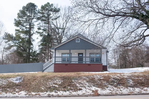 a view of a house with a yard covered in snow