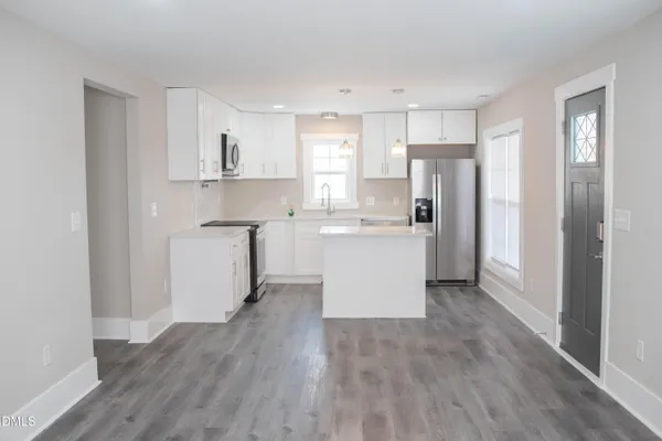 a kitchen with stainless steel appliances a refrigerator sink and cabinets