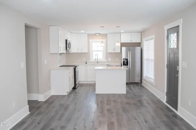 a kitchen with stainless steel appliances a refrigerator sink and cabinets