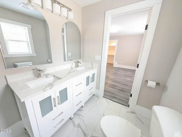 a bathroom with a double vanity sink mirror and toilet