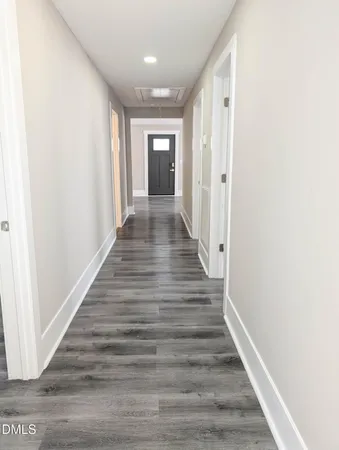 a view of a hallway with wooden floor
