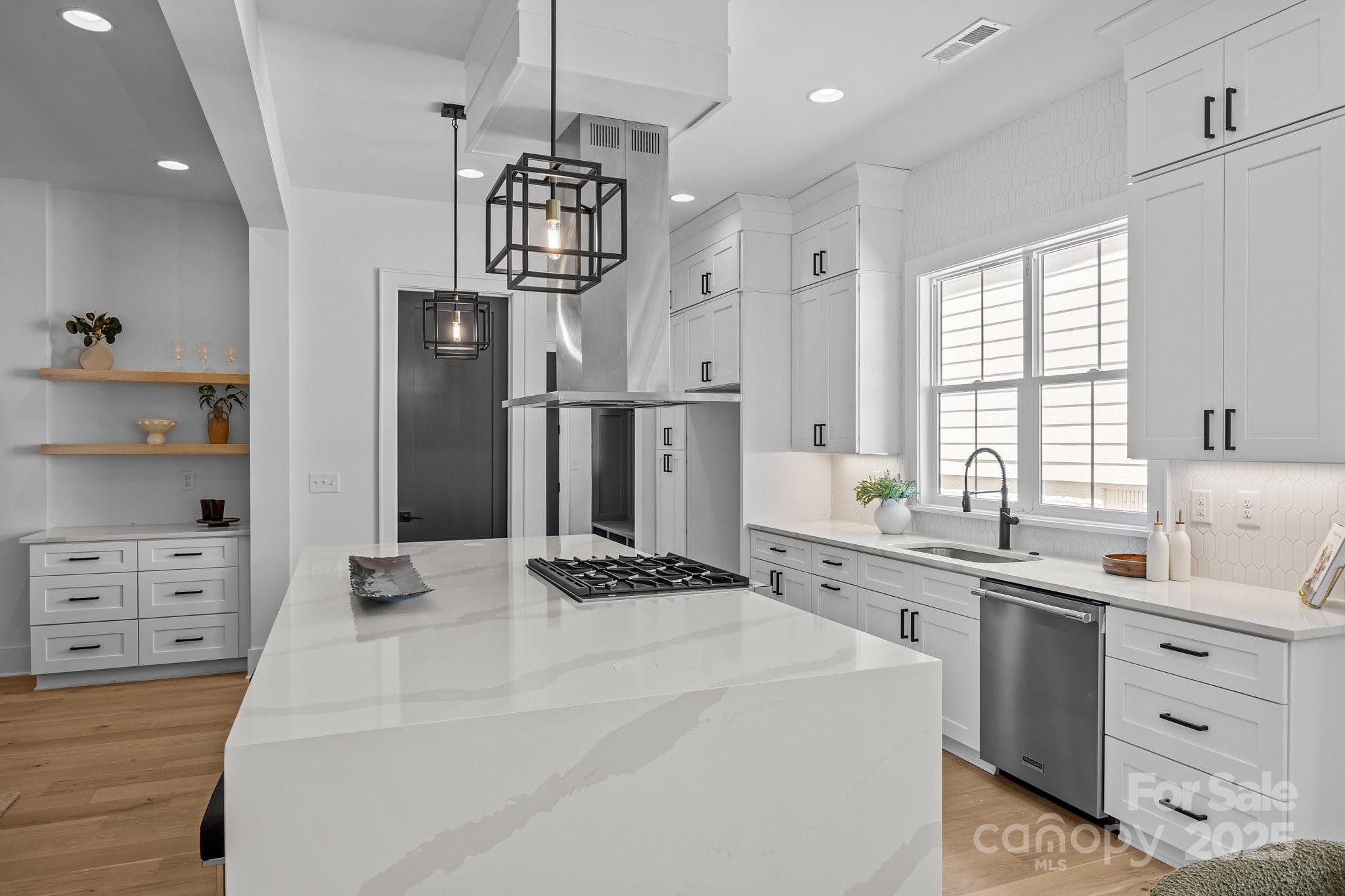 3949 Plainview Road Charlotte, NC 28208 - Photo 16 of 42 a kitchen with a refrigerator a sink dishwasher a stove and white cabinets with wooden floor