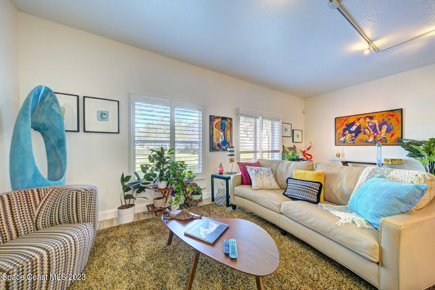 2760 Revolution Street, Unit 103 Melbourne, FL 32935 - Photo 16 of 40 a living room with furniture and a potted plant