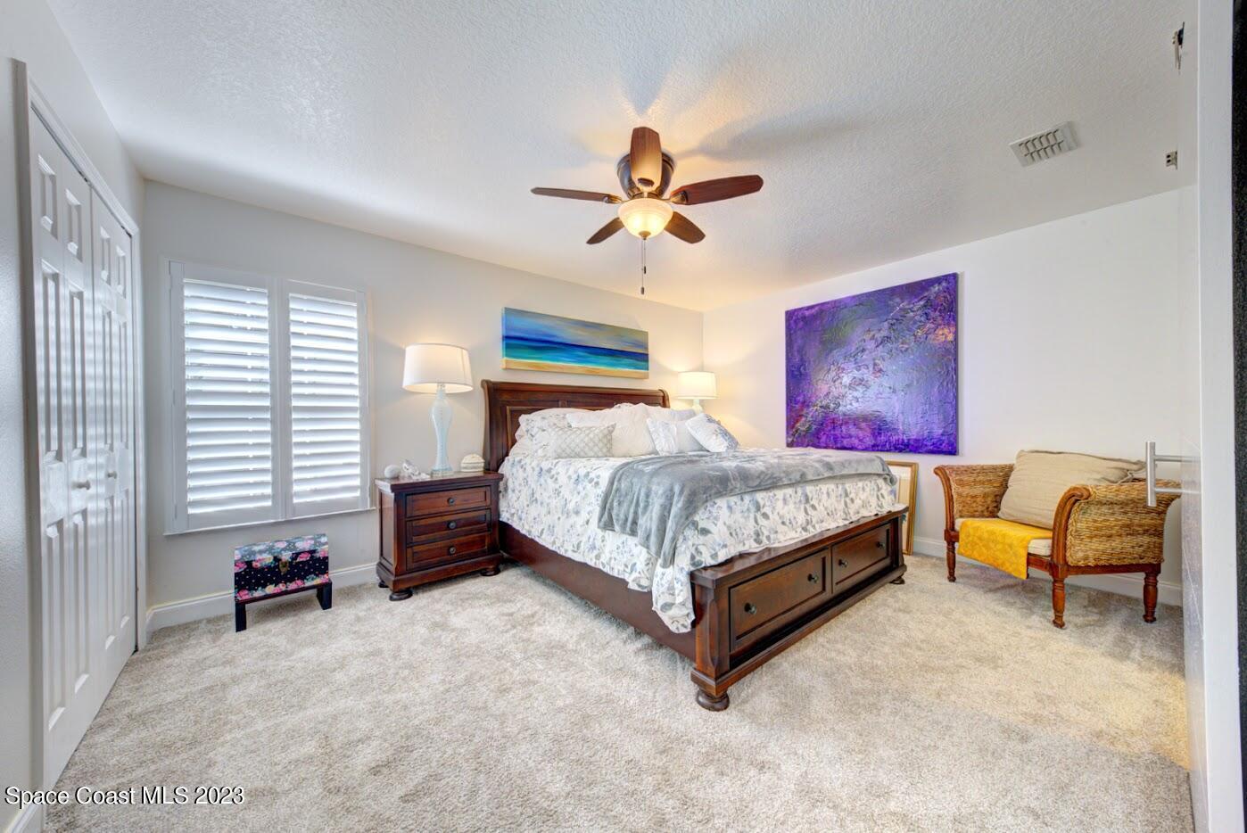 2760 Revolution Street, Unit 103 Melbourne, FL 32935 - Photo 23 of 40 a bedroom with a bed and a chandelier